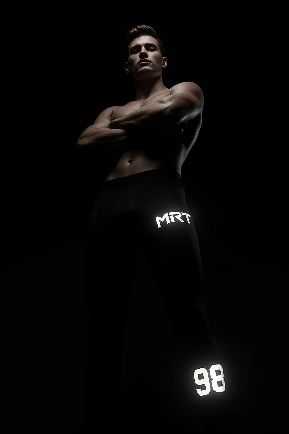 Black Reflective Sport Joggers with MRT Logo and 98 Graphic Worn by Man