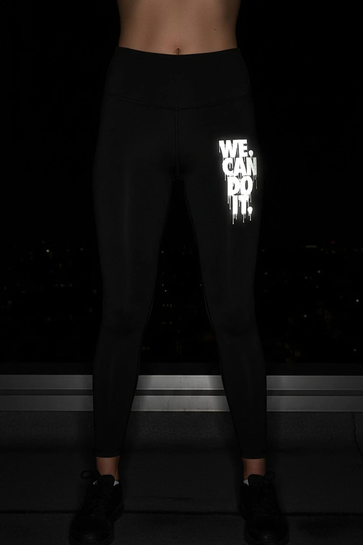 Reflective 'We Can Do It' legging in black with high-visibility print glowing on the thigh