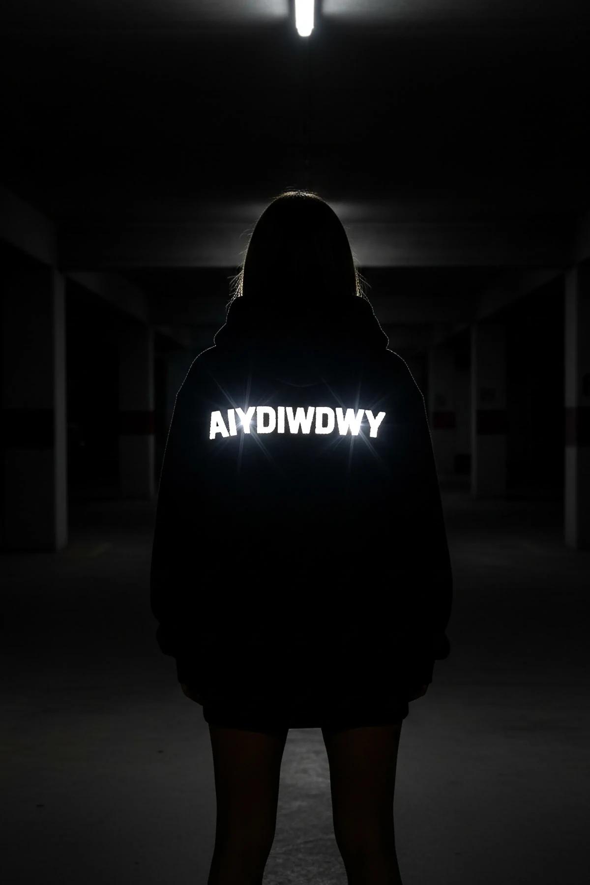 Reflective glow-in-the-dark hoodie black custom text back view glowing in dark tunnel setting