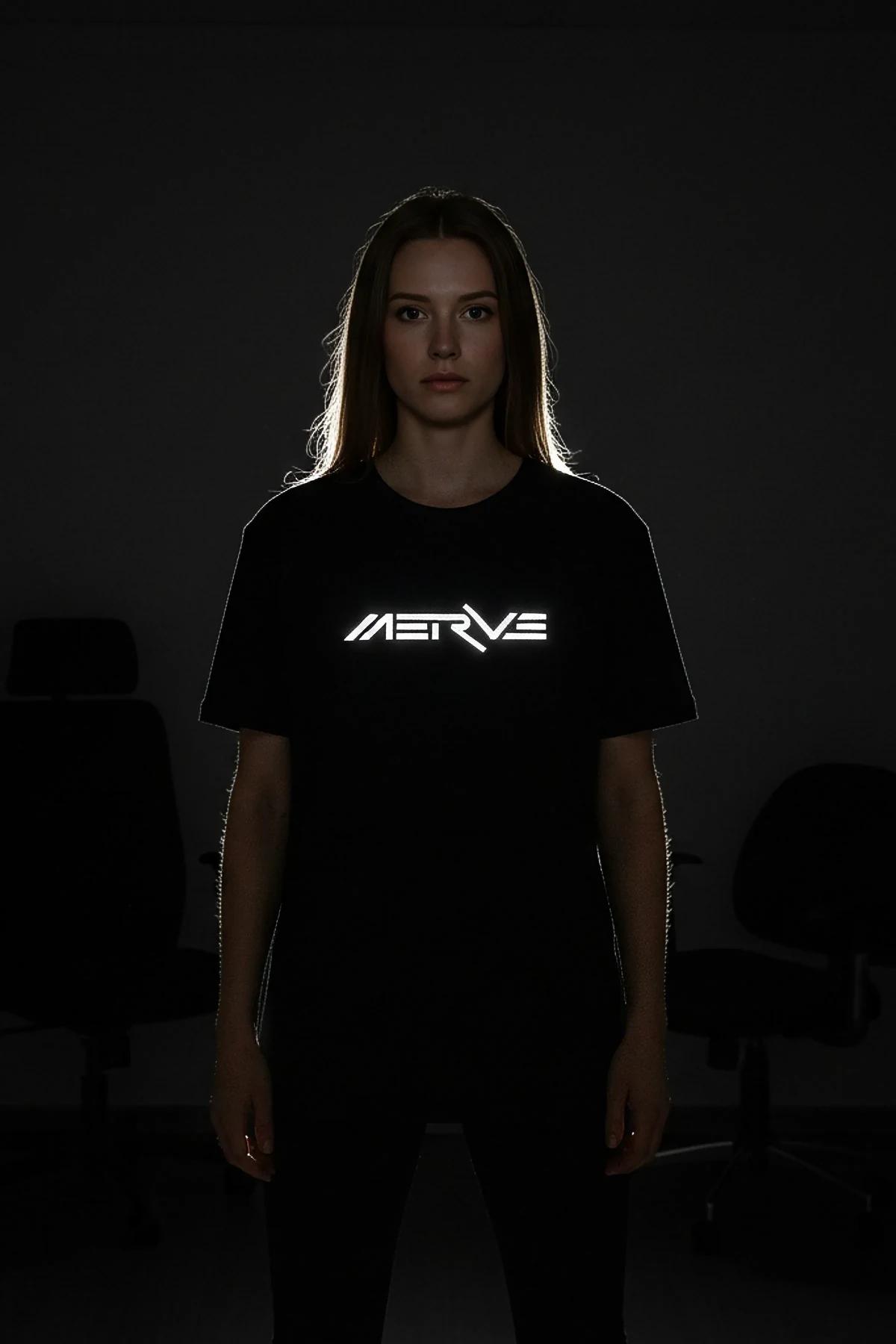 Dark grey t-shirt with bright reflective 'MERVY DANCE' graphic worn by a person, front view