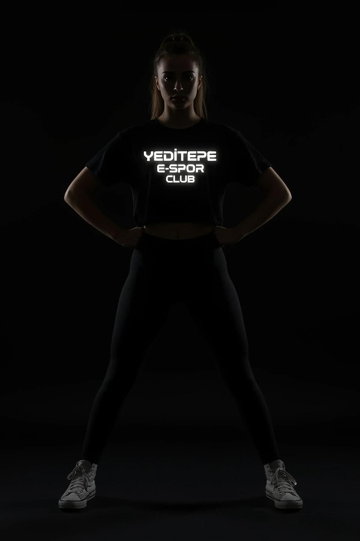 Black reflective logo crop t-shirt worn by a woman.