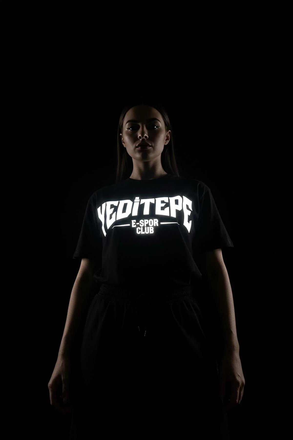 Black reflective logo crop t-shirt worn by a woman.