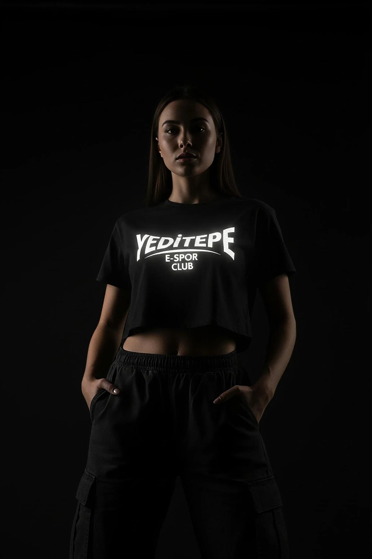 Black reflective logo crop t-shirt worn by a woman.