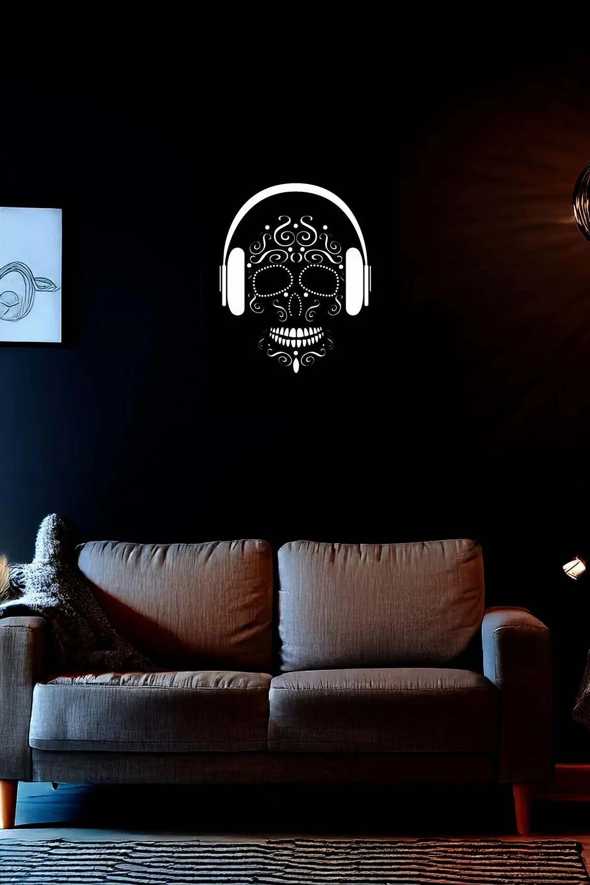 Reflective sugar skull wall art with headphones in white on dark wall above sofa in living room setting