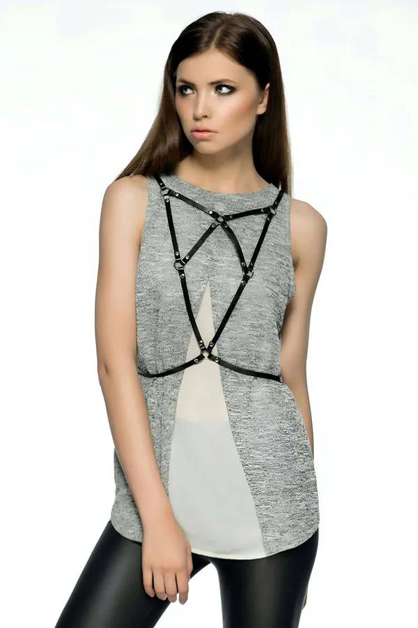 black faux leather geometric body harness with silver O-ring accents at strap intersections worn over grey top