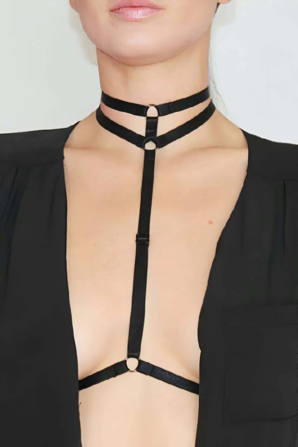 Black double strap choker body harness with gold O-ring hardware and vertical center strap worn over open black blazer